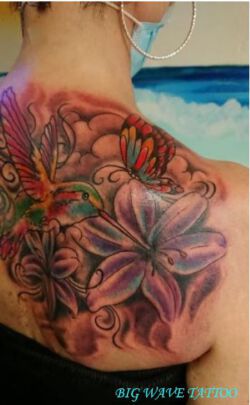 Asiatisches Tattoo mit Kolibri, Schmetterling und Lilien in Farbe