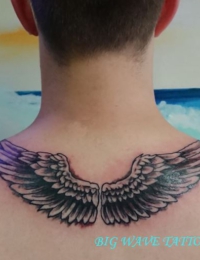 Symmetrisches Nacken- und Rücken-Tattoo eines Mannes, das zwei ausgebreitete Engelsflügel mit detailreich schattierten Federn im Black-and-Grey-Stil zeigt, gestochen von BIG WAVE TATTOO PRIVATE & ART.