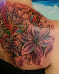 Asiatisches Tattoo mit Kolibri, Schmetterling und Lilien in Farbe