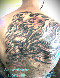 Erste Sitzung eines großflächigen japanischen Rückentattoos (Full Backpiece). Das Motiv zeigt das präzise Linework eines Wasserdrachen (Ryu) auf dem unteren Rücken und bereits dicht schattierte Black-and-Grey-Sturmwolken sowie Windhosen auf den Schultern und dem oberen Rücken, gestochen von BIG WAVE TATTOO PRIVATE & ART.