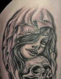 Nahaufnahme eines Tattoos im weichen Black-and-Grey-Stil, das das Gesicht einer La Catrina mit traditionellem Tag-der-Toten-Make-up und Kopfschleier zeigt, die sich an einen detailreich schattierten Totenkopf schmiegt, gestochen von BIG WAVE TATTOO PRIVATE & ART.