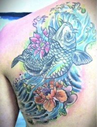 Großflächiges japanisches Tattoo auf dem oberen Rücken und dem Schulterblatt. Zu sehen ist ein detailreich geschuppter Koi-Karpfen in Black-and-Grey, umgeben von einer pinkfarbenen Lotusblüte und einer großen orange-pinken Pfingstrose (Botan). Der Hintergrund ist in dynamischen blau-türkisen und hellgrünen Wellenstrukturen gestaltet, gestochen von BIG WAVE TATTOO PRIVATE & ART.