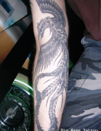 Detailreiches japanisches Tattoo eines Phönix (Hōō) auf dem Unterarm. Das Motiv zeigt den stolzen Kopf, weit geöffnete Flügel und lange, geschwungene Schwanzfedern, vollständig umgesetzt in feinen Black-and-Grey-Schattierungen von BIG WAVE TATTOO PRIVATE & ART.